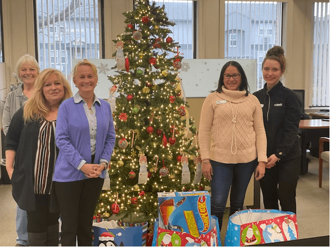 People's Credit Union Employees Gather Around Salvation Army Holiday Angel Tree Program Donations Photo