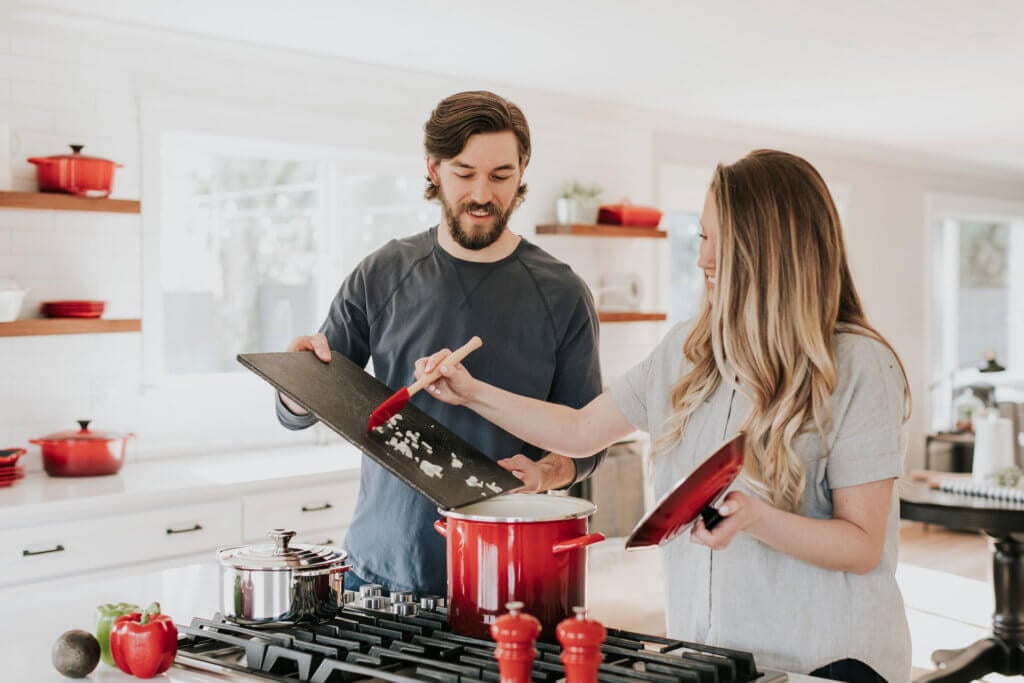 A couple cooking in a kitchen.