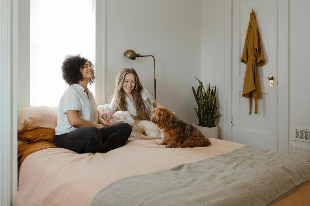 A couple in their bedroom with their 2 dogs.