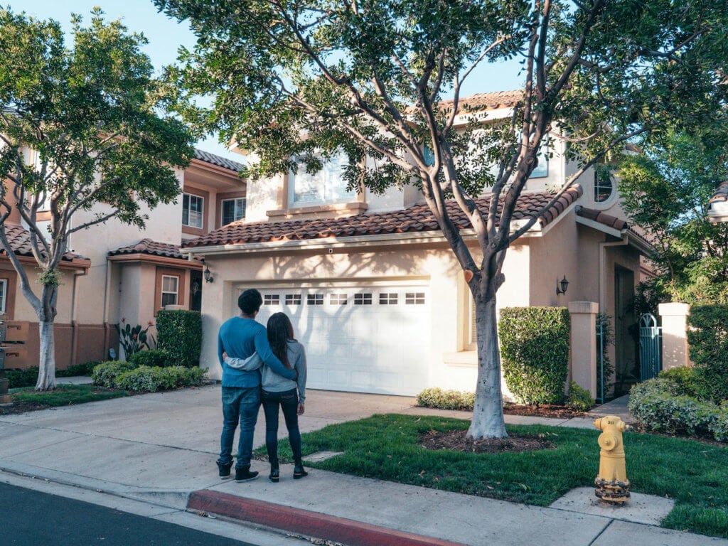 Couple looking at the exterior of their new home.